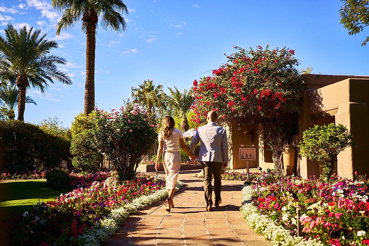 Couple walking through bougainvillea garden toward Lon's at the Hermosa