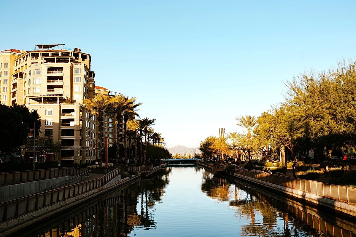 Scottsdale Waterfront canal at golden hour with luxury condos and palm-lined walkway